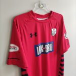 Koszulka piłkarska meczowa klubu Queen's Park FC z sezonu 2018-19 w kolorze czerwonym marki Under Armour.