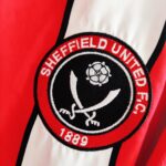 Domowa koszulka klubu Sheffield United z sezonu 2004-05 w kolorze czerwono-białym marki Le Coq Sportif.