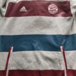 Blzua z kapturem Bayern Monachium z sezonu 2014-15 w kolorze szarym marki Adidas.
