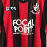 Domowa koszulka piłkarska Bournemouth (#11 L. Feeney) z sezonu 2011-12 w kolorze czerwono-czarnym marki Fila.