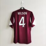 Domowa koszulka piłkarska Heart of Midlothian (#4. D Wilson) z sezonu 2013-14 w kolorze burgundowym marki Adidas.