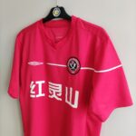 Domowa koszulka piłkarska Chengdu Blades z sezonu 2006 w kolorze czerwonym marki Umbro.