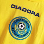 Wyjazdowa koszulka reprezentacji Kazachstan 2006-07 w kolorze żółtym marki Diadora.