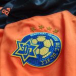 Bluza bramkarska Maccabi Tel Aviv z sezonu 2014-15 w kolorze pomarańczowo-czarnym marki Adidas.
