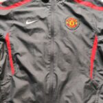 Bluza treningowa 2010-11 Manchester United z sezonu 2010-11 w kolorze szaro-czerwonym marki Nike.
