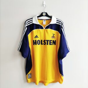 Wyjazdowa koszulka Tottenham Hotspur z sezonu 1999-00 w kolorze żółto-granatowym marki Adidas.
