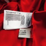 Metka koszulki Odds BK z sezonu 2011 w kolorze czerwonym marki Adidas.