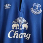 Domowa koszulka Europa League Everton (#26 J. Stones) z sezonu 2014-15 wkolorze niebieskim marki Umbro.