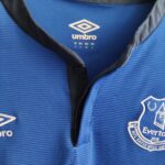 Domowa koszulka Europa League Everton (#26 J. Stones) z sezonu 2014-15 wkolorze niebieskim marki Umbro.