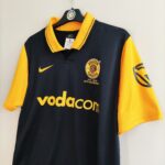 Wyjazdowa koszulka Kaizer Chiefs z sezonu 2010-11 w kolorze czarno-żółtym marki Nike.