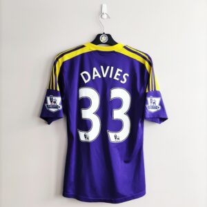Wyjazdowa koszulka Swansea City (#33 B. Davies) z sezonu 2013-14 w kolorze fioletowo-żółtym marki Adidas.