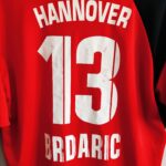 Domowa koszulka Hannover 96 (#31. T Brdaric) z sezonu 2005-06 w kolorze czerwono-czarnym marki Diadora.