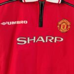 Koszulka domowa Manchester United z sezonu 1998-99 w kolorze czerwonym marki Umbro.